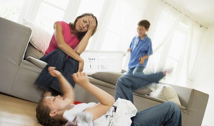 Vollzeitmutter - Kinder spielen und Mutter ist verzweifelt