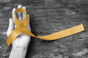 Goldenes Band formt Krebssymbol - Symbol für den Kampf der Superhelden gegen Krebs