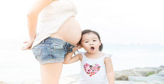 Planung einer zweiten Schwangerschaft - Schwangere Frau mit Tochter 