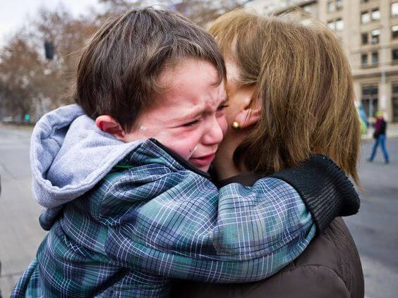 Zu verabschieden - Junge weint in Mamas Armen