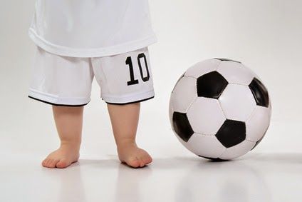 barfüßige Babys mit Fußball