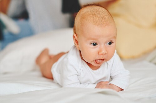 Das Baby auf seinen Bauch zu legen - Baby hebt Kopf