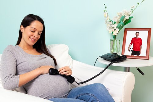 Schwangere telefoniert mit Ungeborenem für pränatale Stimulation