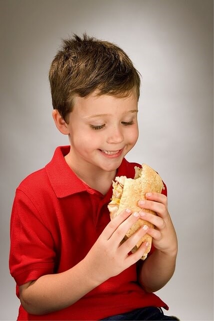 gesunde Snacks - Junge isst Brötchen