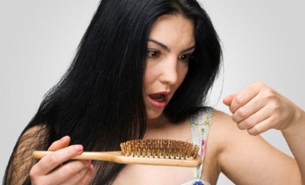 Frau reagiert mit Entsetzen auf den Haarausfall nach der Geburt