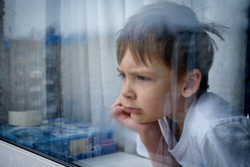 Kind mit Kinderfrustration schaut aus dem Fenster.