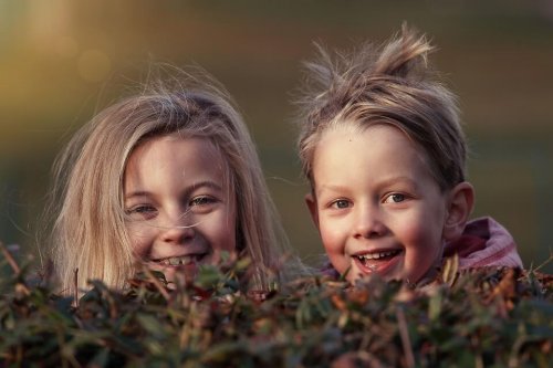 Gleichalrige Cousins können miteinander spielen, während sich die Erwachenen unterhalten