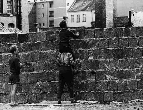 guter Vater mit Kindern vor Mauer
