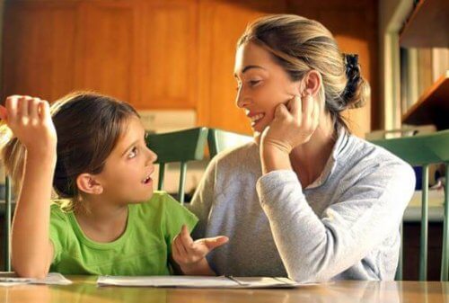 Die Mutter redet mit ihrem Kind zusammen am Tisch, um die Disziplinierung ihres Kindes zu erreichen.