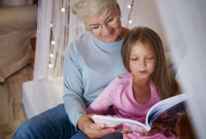 Frau ist zum ersten Mal Oma und liest mit ihrem Enkelkind