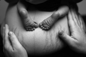 Bauch mit Babyfüßen