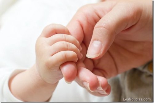 Babyhand hält Finger von Mutter