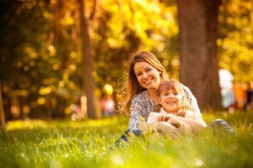 Mutter sitzt mit Kind im Park.