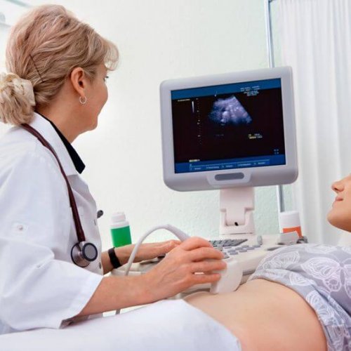 Ärztin macht Ultraschall bei schwangeren Frau.