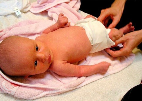 Mutter wechselt Windel ihres Babys.