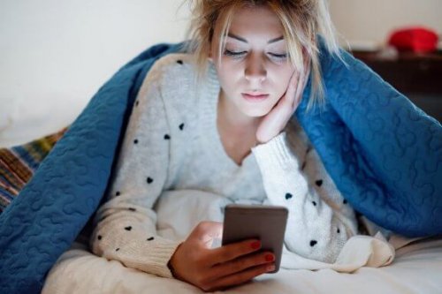 Die sozialen Netzwerke des Partners kontrollieren - Frau schaut auf ihr Smartphone