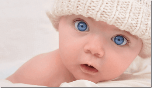 Baby mit blauen Augen schaut in die Kamera.