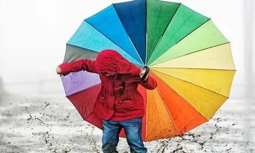 Kind mit buntem Regenschirm