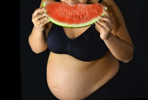 Schwangere Frau isst eine Wassermelone