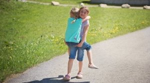 Mädchen trägt Schwester auf dem Arm