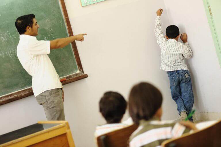 Ordnungsmaßnahmen - Junge steht in der Klasse in der Ecke