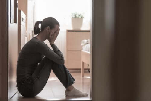 Depressionen - Frau sitzt weinend auf dem Boden