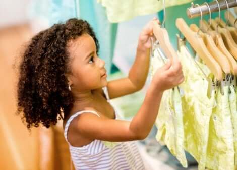 Kleines Mädchen betrachtet Kleider