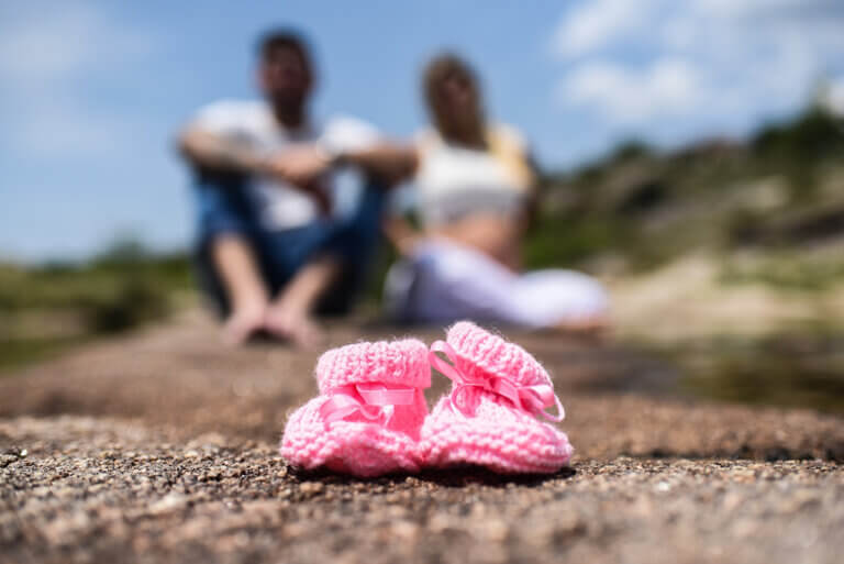 paar hat sich verlobt, im vordergrund babyschuhe